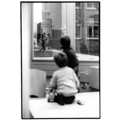 Kinderen kijkend door raam / analoge dokaprint (site = scan dokaprint)